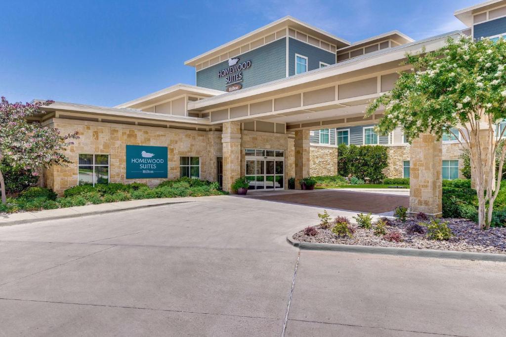 Un grand bâtiment avec une allée se trouve en face de l'établissement. dans l'établissement Homewood Suites by Hilton Fort Worth Medical Center, à Fort Worth