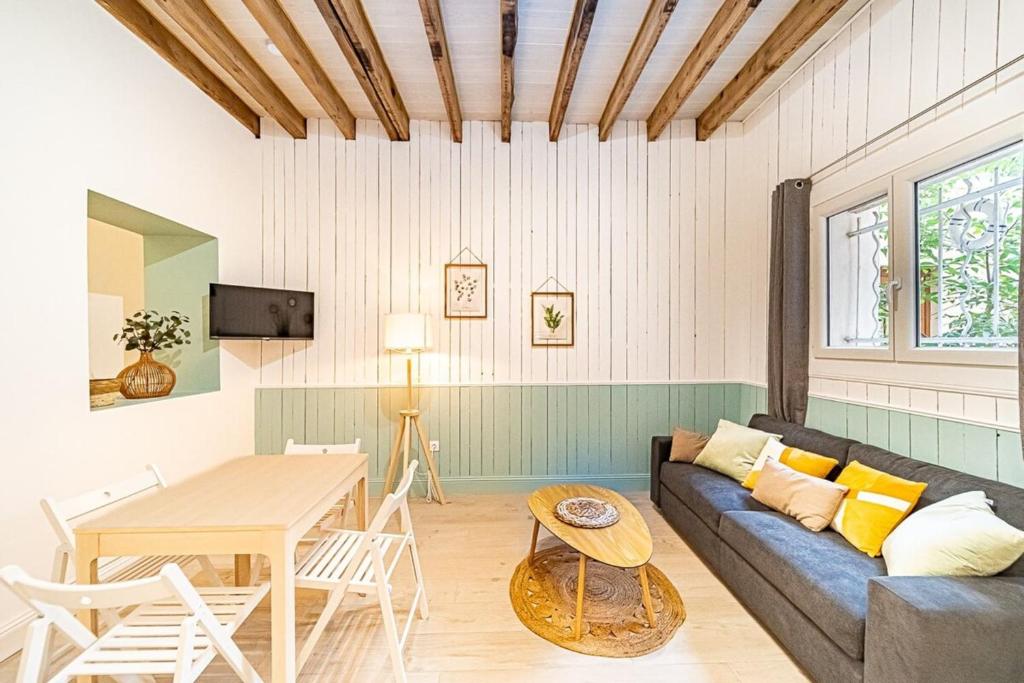 een woonkamer met een bank en een tafel bij La Maison Charpennes-appartement Eucalyptus 4 pers in Villeurbanne