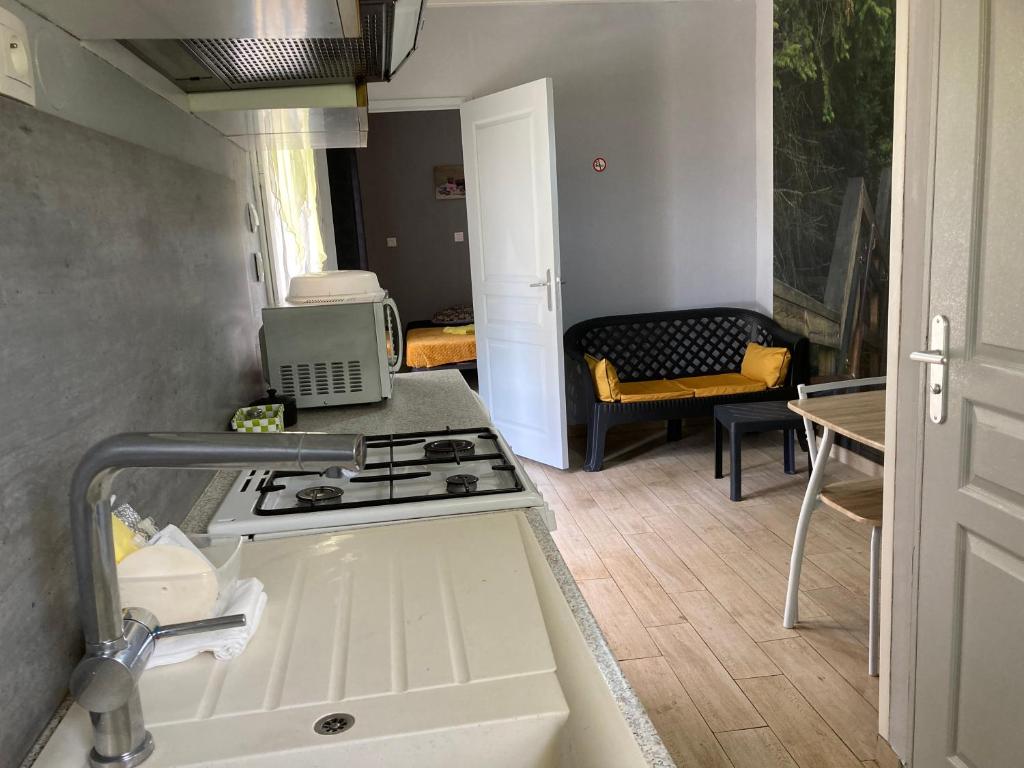 a kitchen with a sink and a stove top oven at F1 noir&#47;anis, avec terrasse couverte et jardin (E) in Compreignac