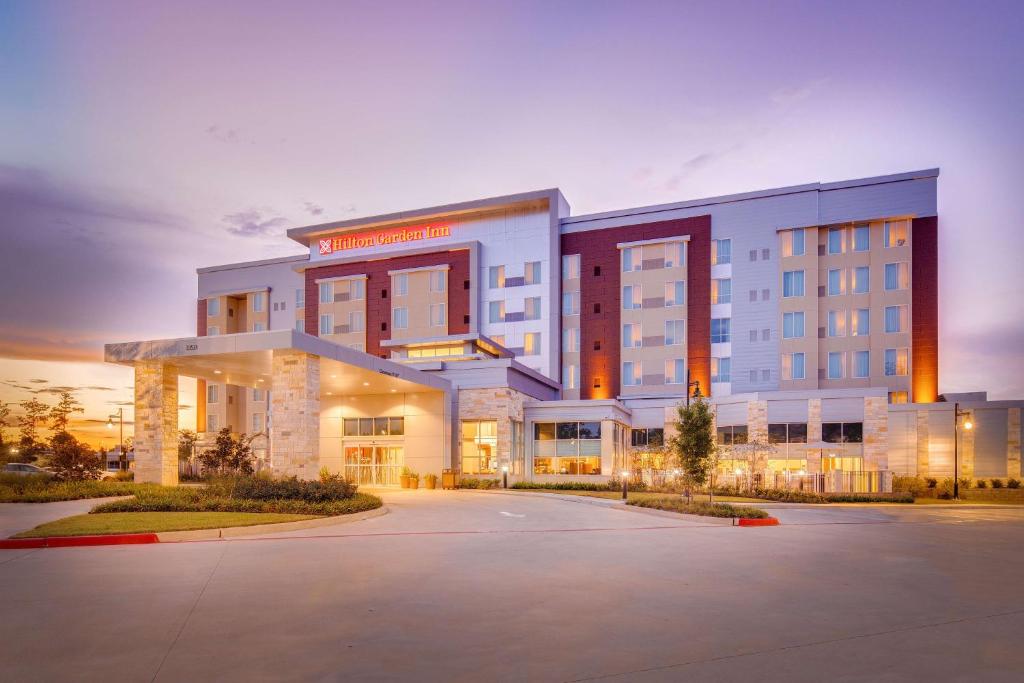 ein Hotel mit Parkplatz davor in der Unterkunft Hilton Garden Inn North Houston Spring in Spring