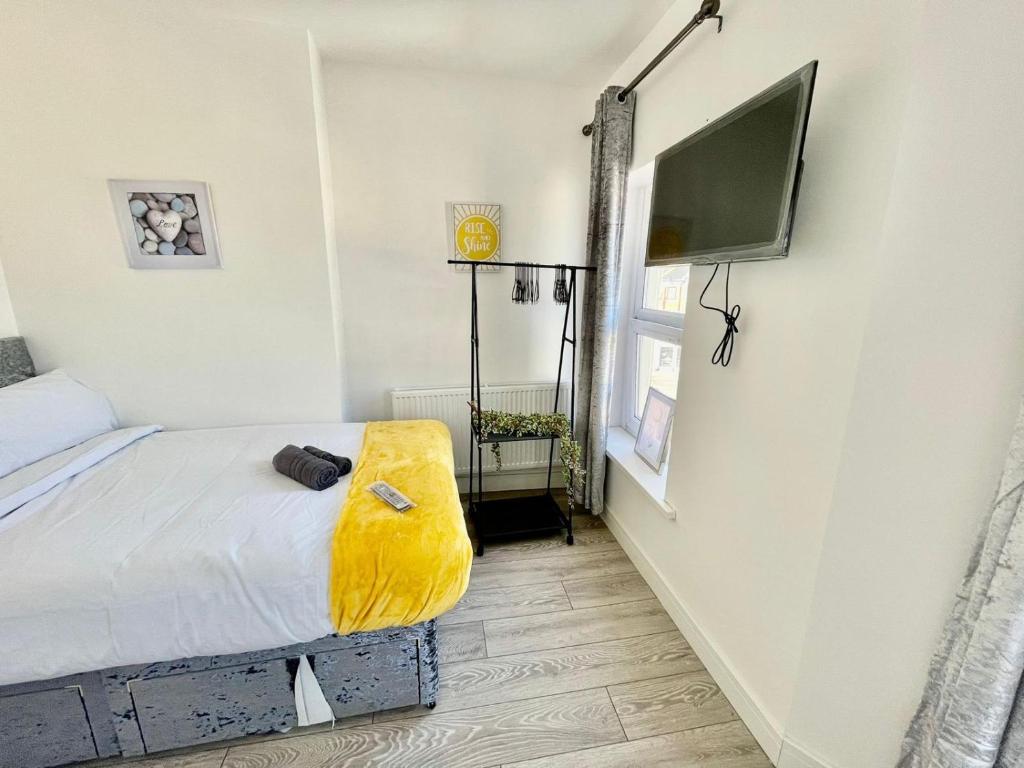 um quarto com uma cama e uma televisão de ecrã plano em Cheerful 1 Bed Apartment Cardiff City Centre - Penarth Rd em Cardiff