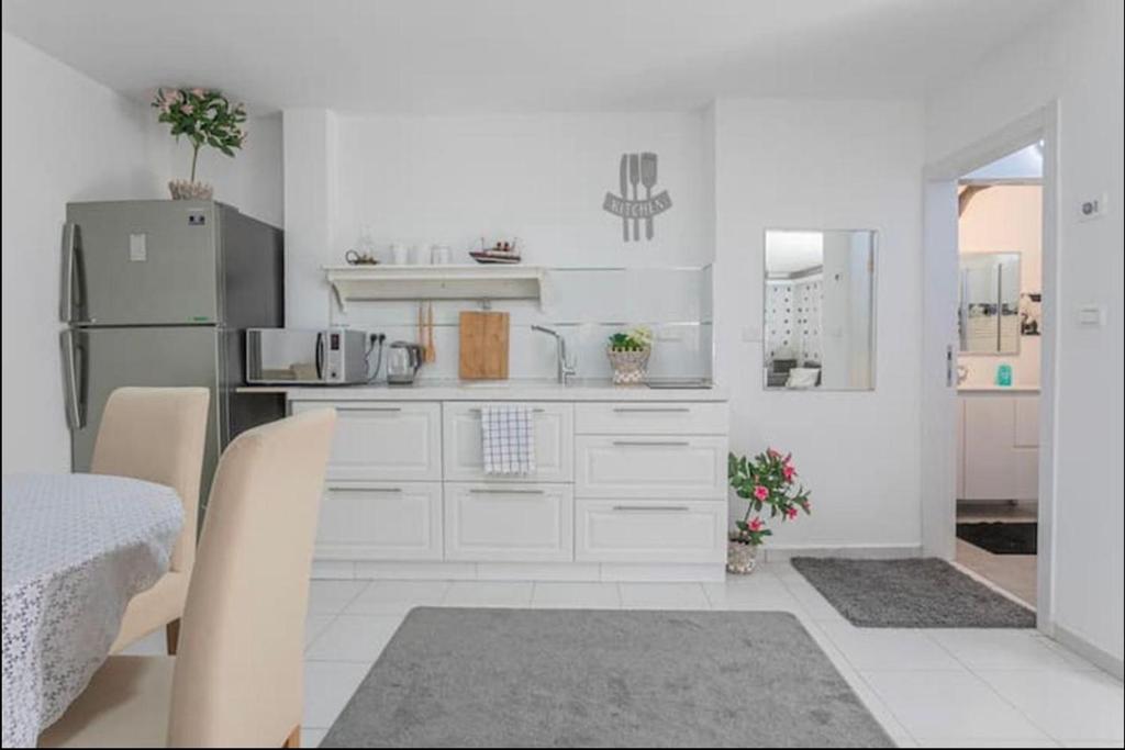 uma cozinha com armários brancos e um frigorífico em Kamer guesthouse em Bersebá