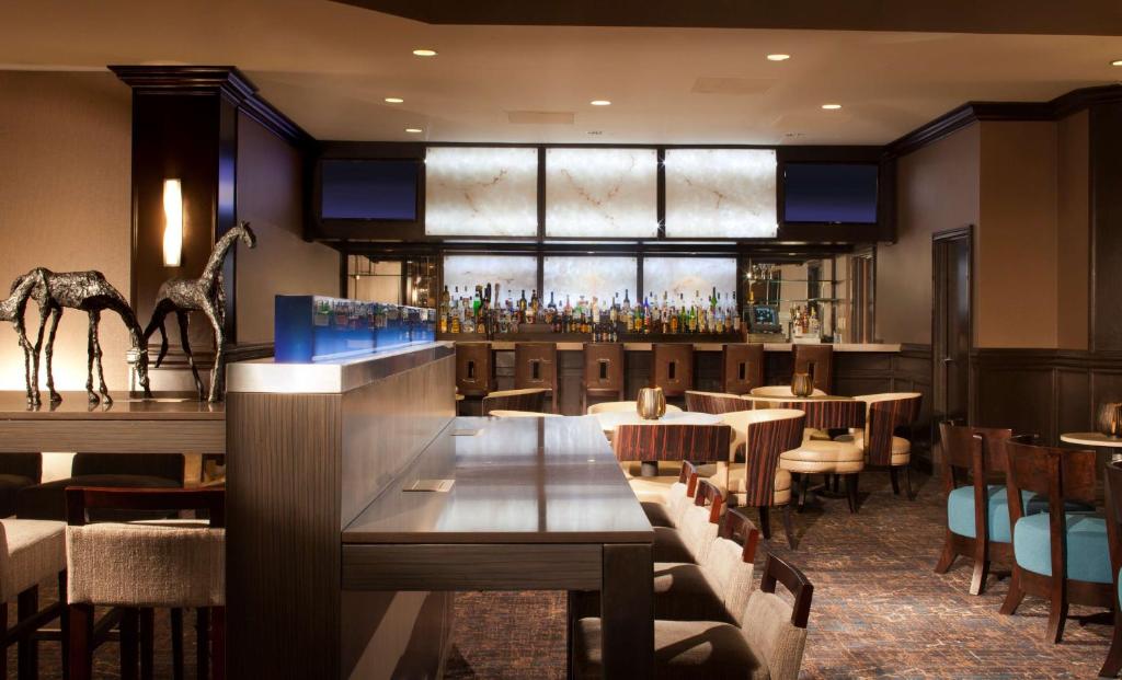 een restaurant met tafels en stoelen en een bar bij Embassy Suites by Hilton Houston Near the Galleria in Houston