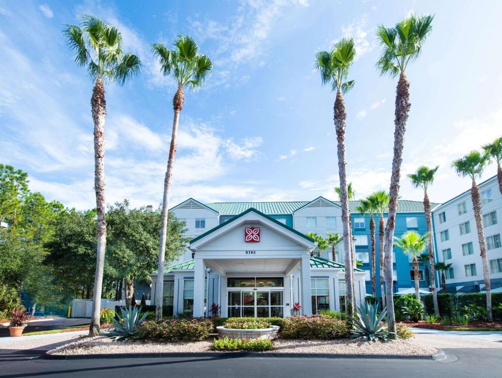 a hotel with palm trees in front of it at Hilton Garden Inn Jacksonville JTB/Deerwood Park in Jacksonville