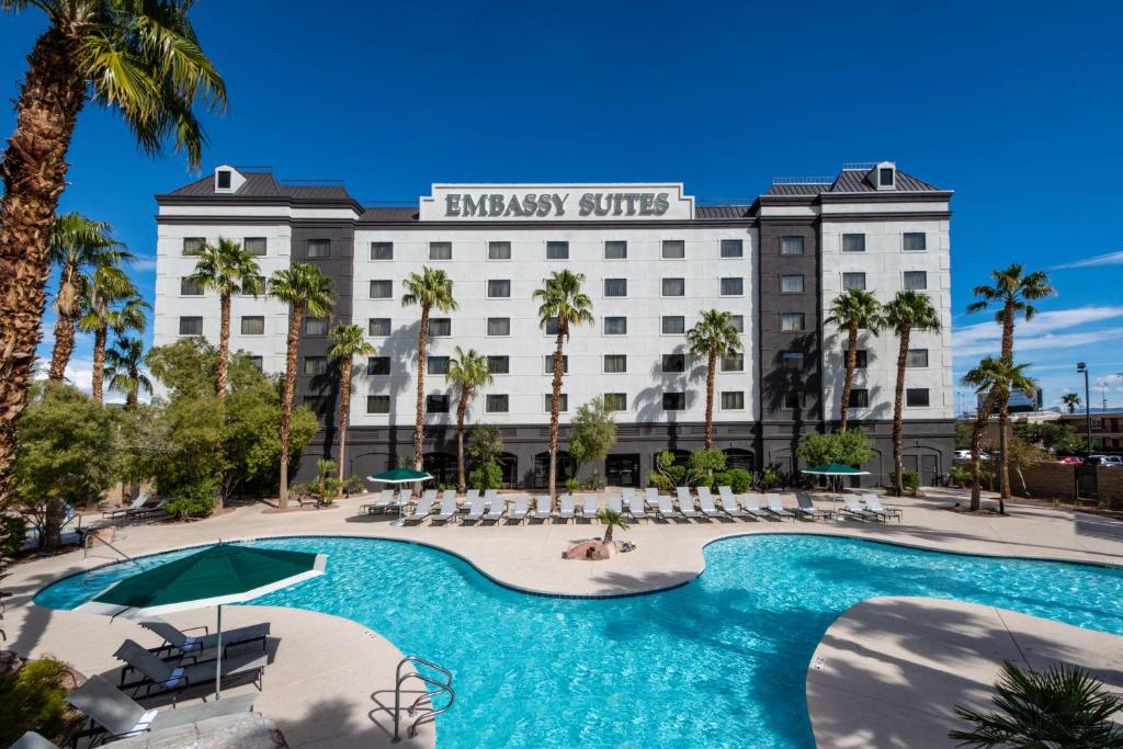 a hotel with a swimming pool and palm trees at Embassy Suites by Hilton Las Vegas in Las Vegas