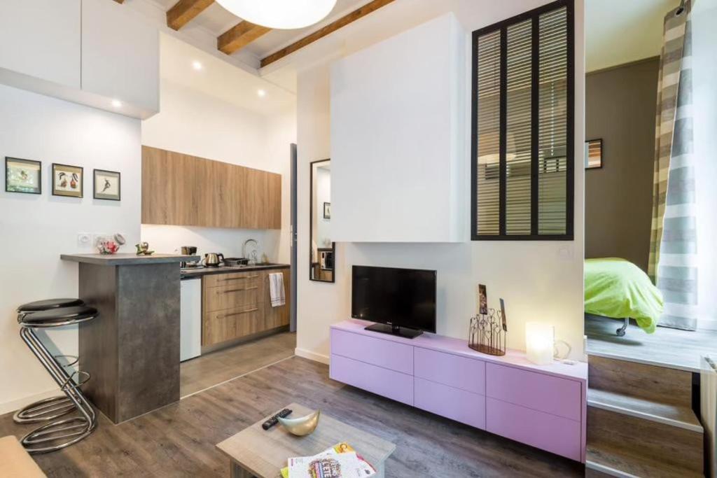 a kitchen and living room with a purple and white kitchen at Le Petit Domer -métro Garibaldi-Université in Lyon