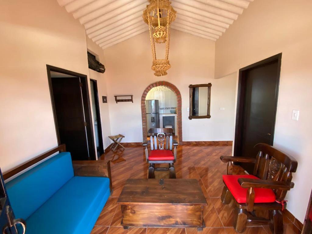 un soggiorno con divano blu e sedie di Casa Montañita del RIO a Aratoca