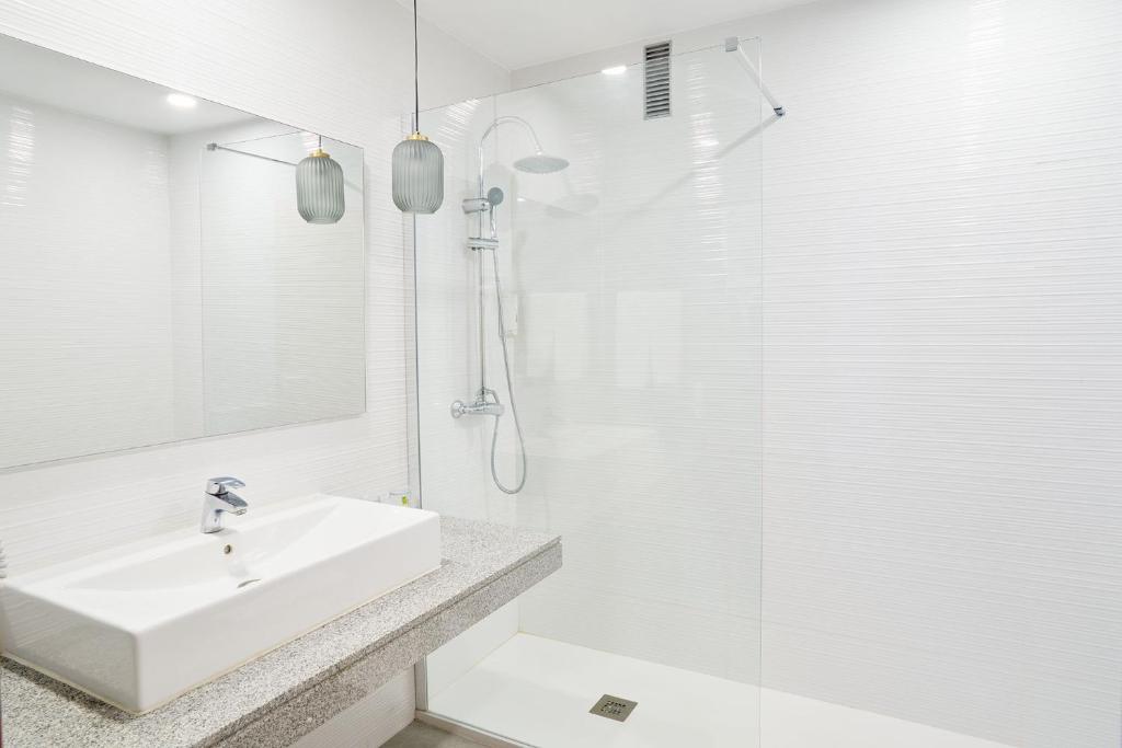 a white bathroom with a sink and a shower at Hotel Torre Del Conde in San Sebastián de la Gomera