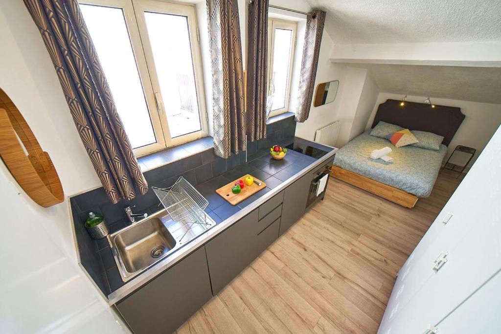 an overhead view of a kitchen with a bed in a room at Le Salengro - Studio cosy - métro Charpennes in Villeurbanne