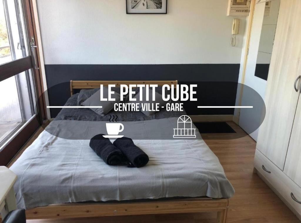 una camera con un letto con due cuscini neri di Le Petit Cube - Résidence standing - Centre ville - Gare a Troyes