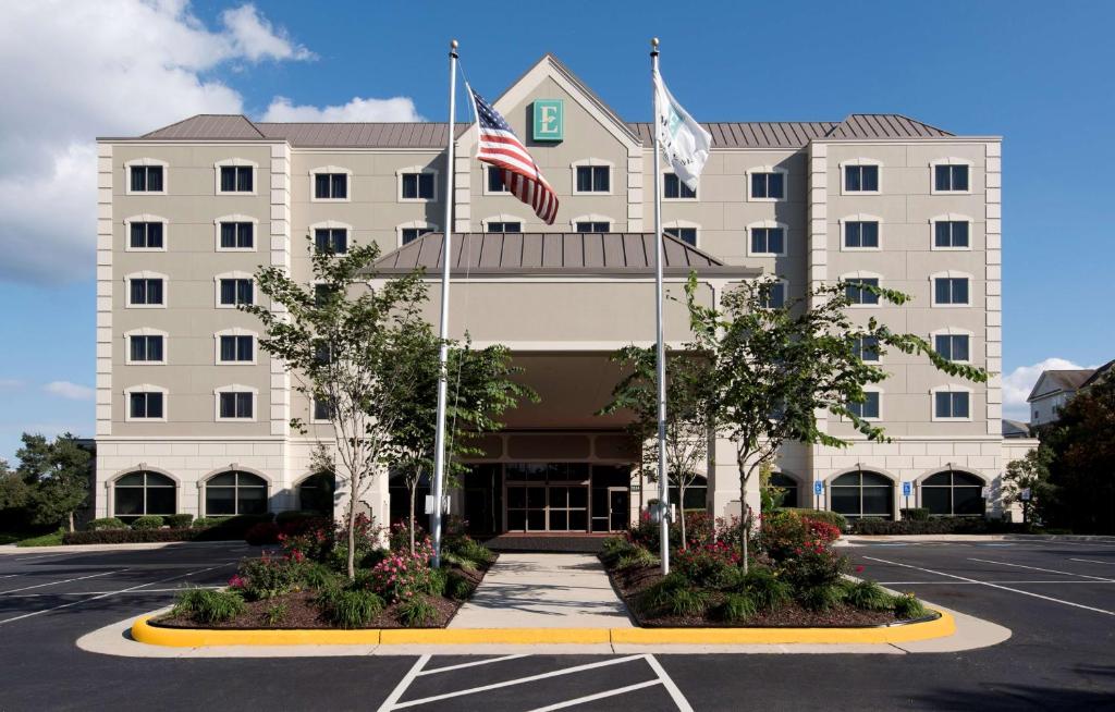 ein Hotel mit zwei Flaggen auf einem Parkplatz in der Unterkunft Embassy Suites by Hilton Dulles Airport in Herndon