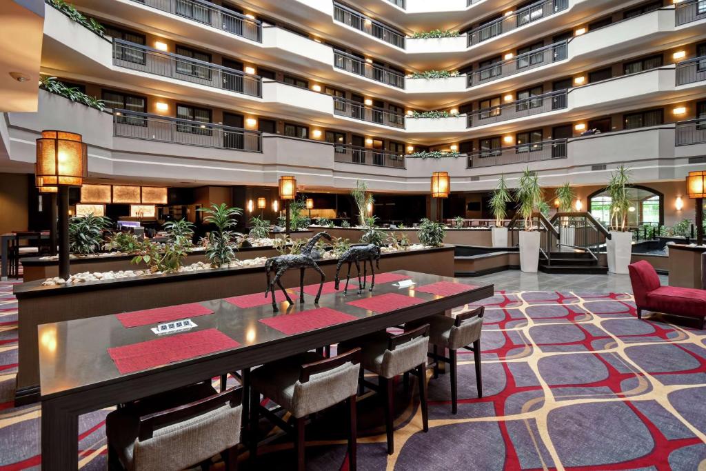 a hotel lobby with a long table and chairs at Embassy Suites by Hilton Dulles Airport in Herndon