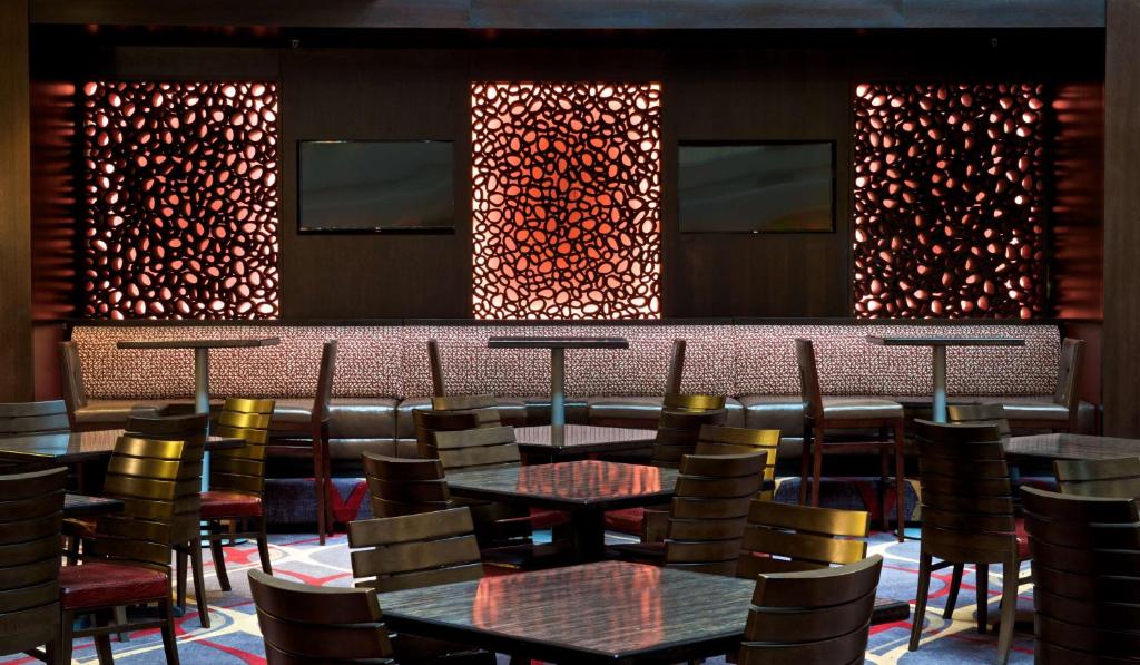 ein Restaurant mit Tischen und Stühlen und einer Bar in der Unterkunft Embassy Suites by Hilton Dulles Airport in Herndon