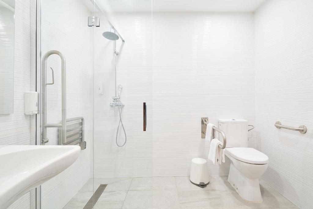 a white bathroom with a shower and a toilet at Hotel Torre Del Conde in San Sebastián de la Gomera
