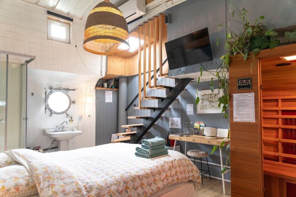 a bedroom with a bed and a staircase and a sink at Peniche Althea in Avignon