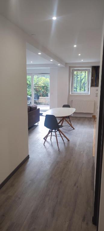 un salon avec une table et deux chaises dans l'établissement meublé neuf avec jardin, à Clairvaux-les-Lacs