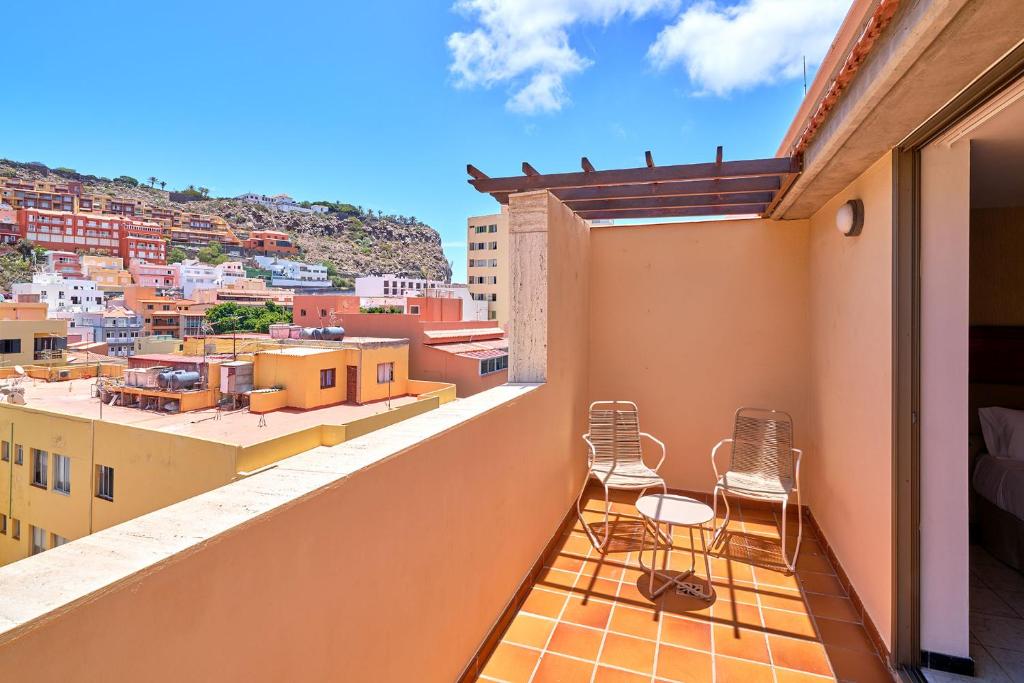 a balcony with chairs and a view of the city at Hotel Torre Del Conde in San Sebastián de la Gomera