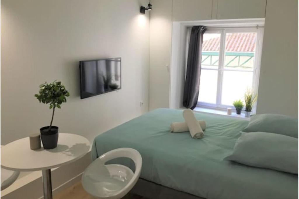 une chambre avec un lit, une table et une fenêtre dans l'établissement Studio Duquesne - Parc Tête d'Or-Metro Fochoch, à Lyon