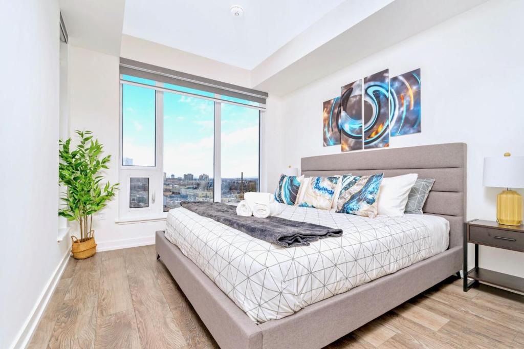 um quarto com uma cama grande e uma janela em Luxurious 1BR Condo - Stunning City Views em Kitchener