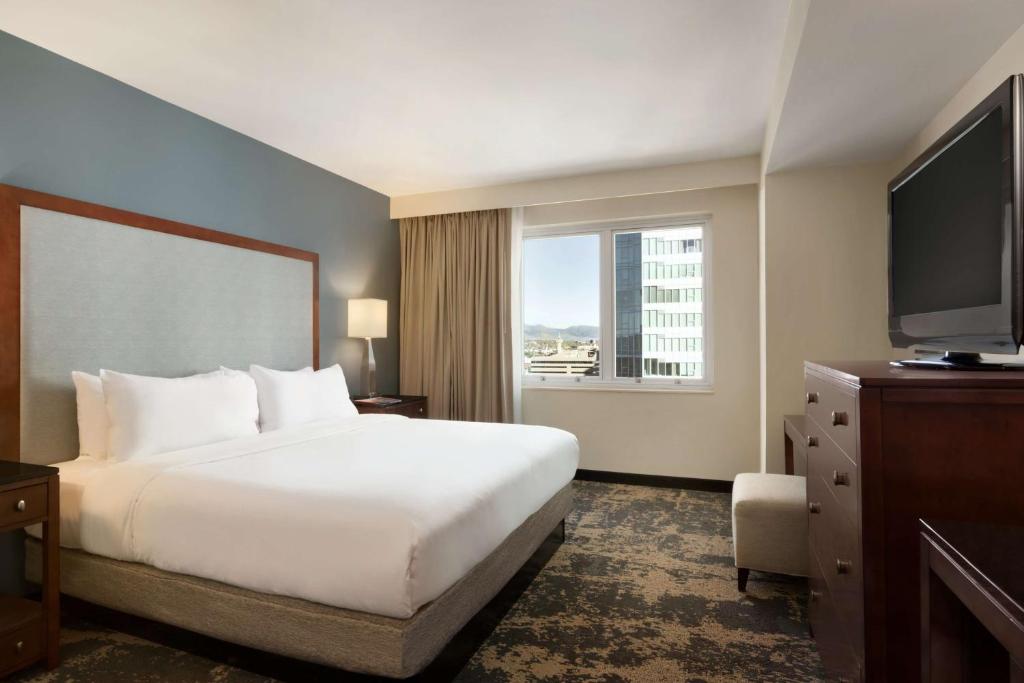 a hotel room with a bed and a large window at Embassy Suites by Hilton Denver Downtown Convention Center in Denver