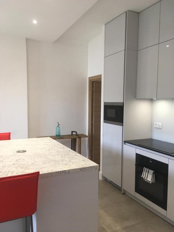 Una cocina con gabinetes blancos y encimera. en Ma terrasse sur le musée, en Chambéry