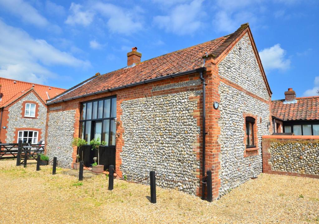 an old brick building with windows on the side at Swallow Barn in Bodham