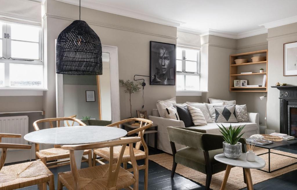 un soggiorno con tavolo e divano di The Leicester Square Apartment By Hok Living a Londra