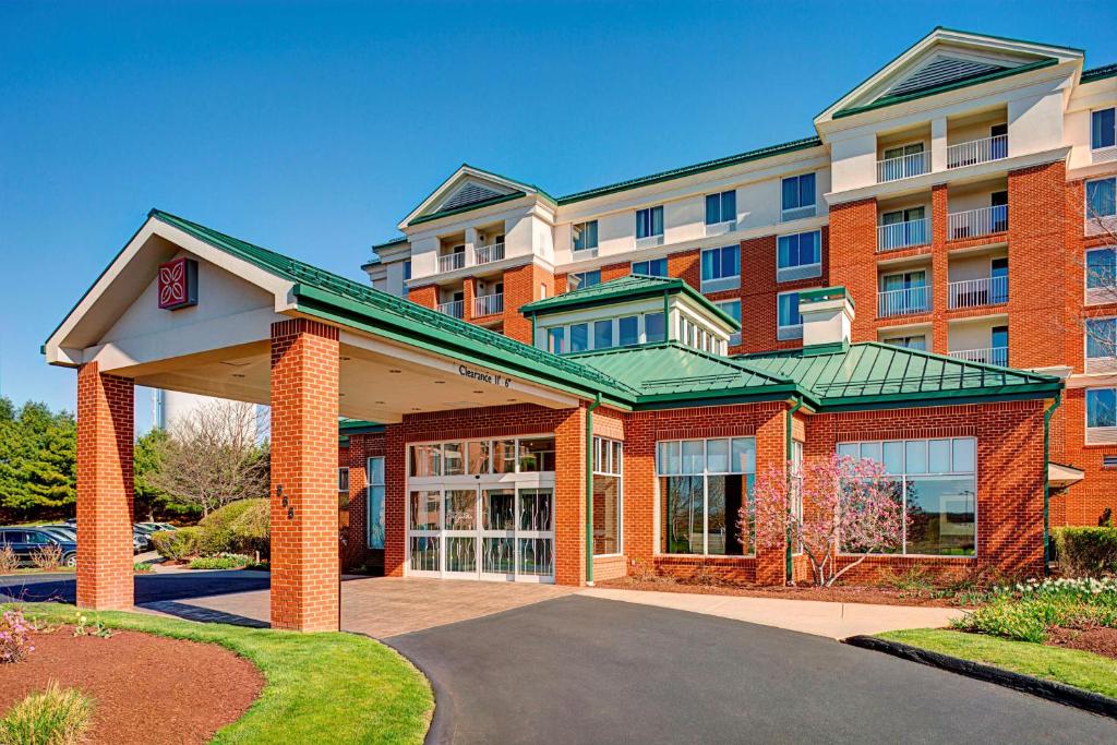 a large building with a parking lot in front of it at Hilton Garden Inn Hartford North-Bradley International Airport in Windsor