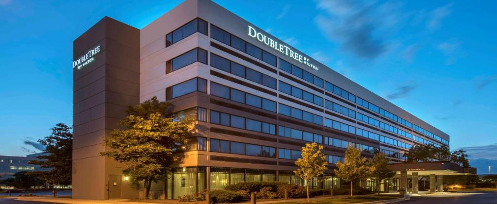 un immeuble de bureaux avec un panneau sur son côté dans l'établissement DoubleTree by Hilton Hotel Chicago - Schaumburg, à Schaumburg