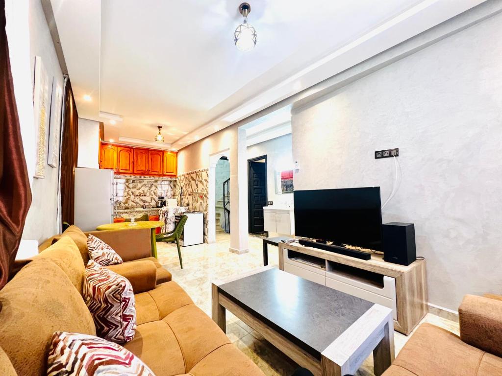 Una sala de estar con un sofá y un televisor. en Al Hanae Family Aparts, en Marrakech