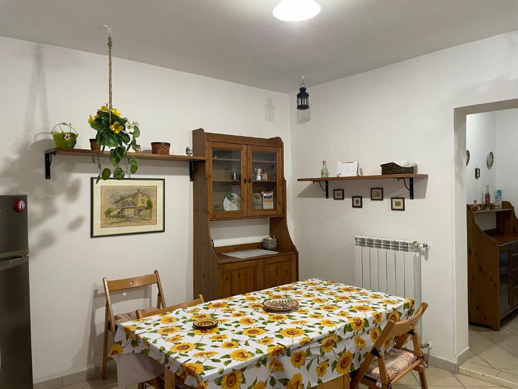 een eetkamer met een tafel met een bloemrijke tafelkleed bij Al Paese Vecchio in Vasanello