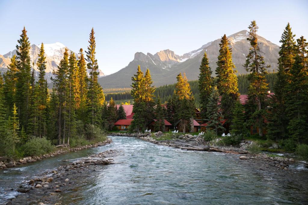 un río fluye a través de un bosque con montañas en Post Hotel & Spa, en Lago Louise