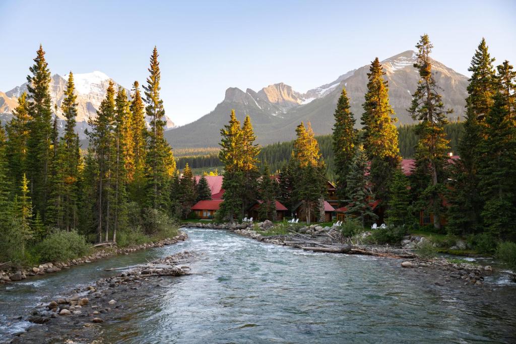a river flows through a forest with mountains at Post Hotel & Spa in Lake Louise