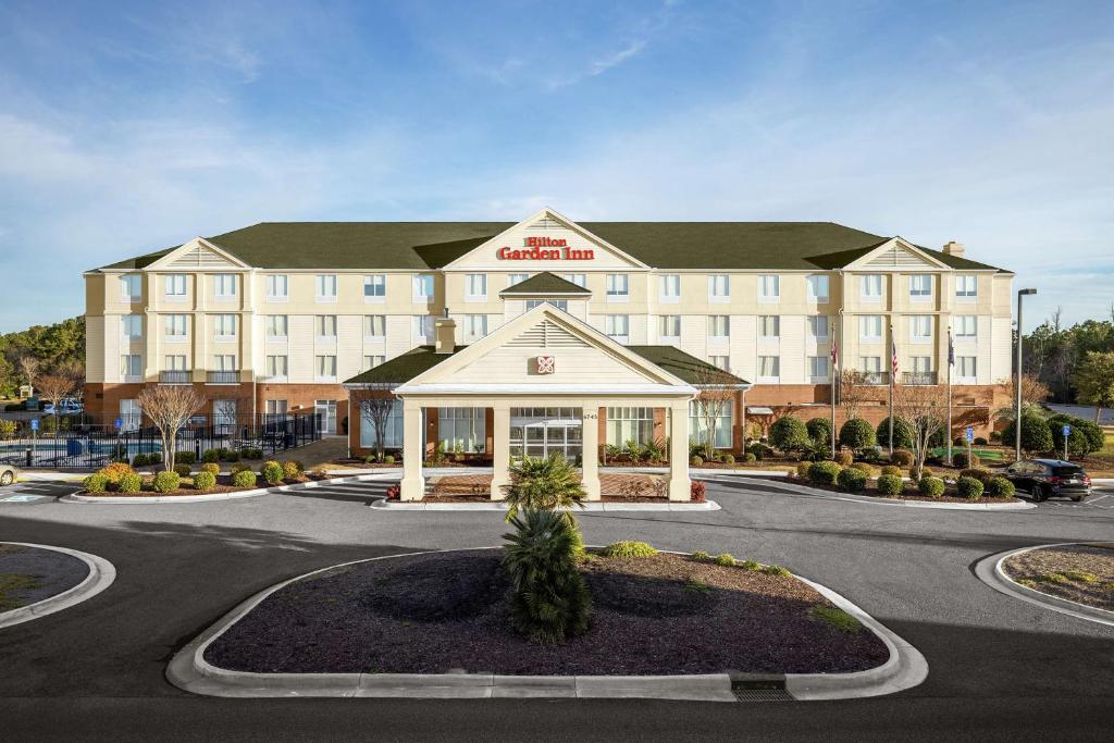 un hôtel avec un grand bâtiment dans un parking dans l'établissement Hilton Garden Inn Wilmington Mayfaire Town Center, à Wilmington