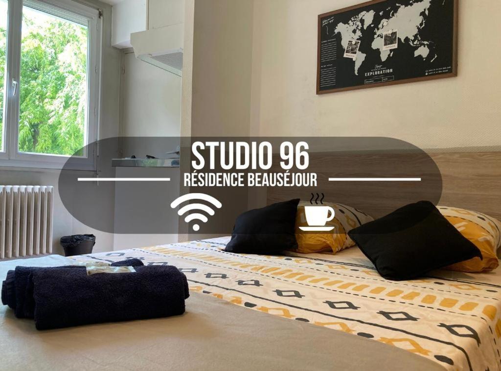 um quarto com uma cama com uma placa em Studio 96 - Wi fi fibre - Résidence Beauséjour - Proche centre ville em Troyes