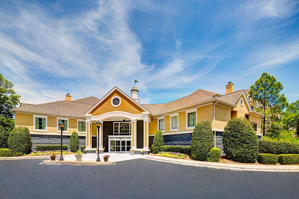 a large yellow house with a driveway at Homewood Suites by Hilton Raleigh/Cary in Cary