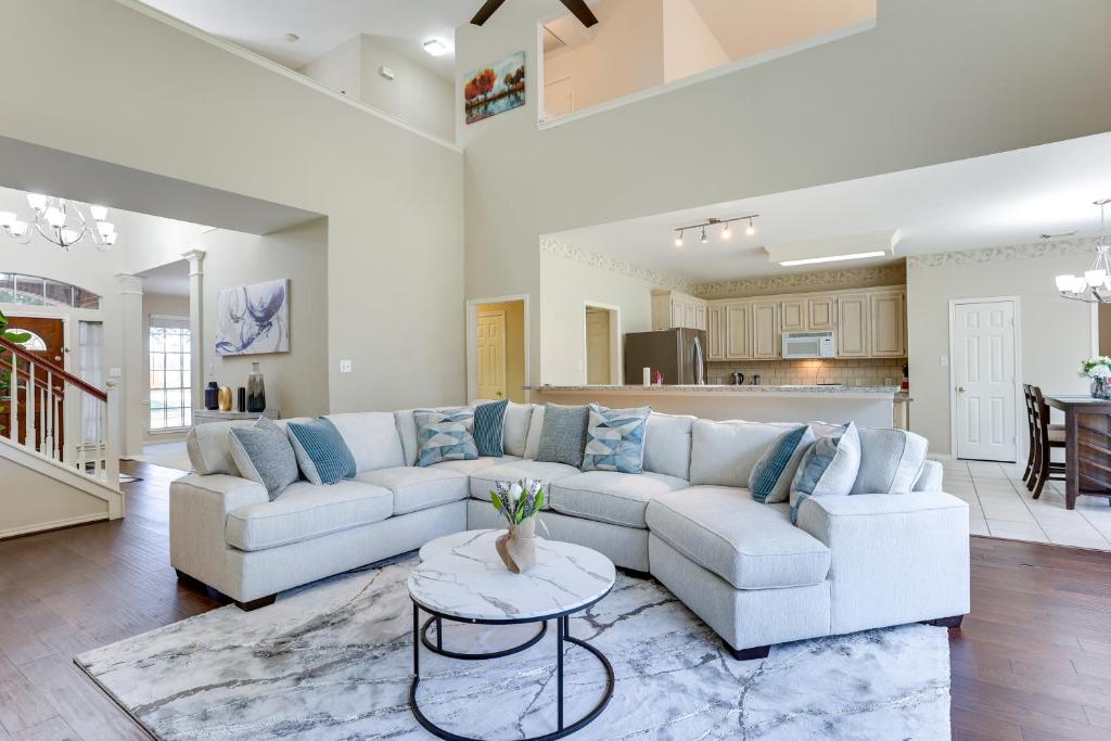 a living room with a white couch and a table at Spacious Sugar Land Retreat with Fireplace and Yard in Sugar Land