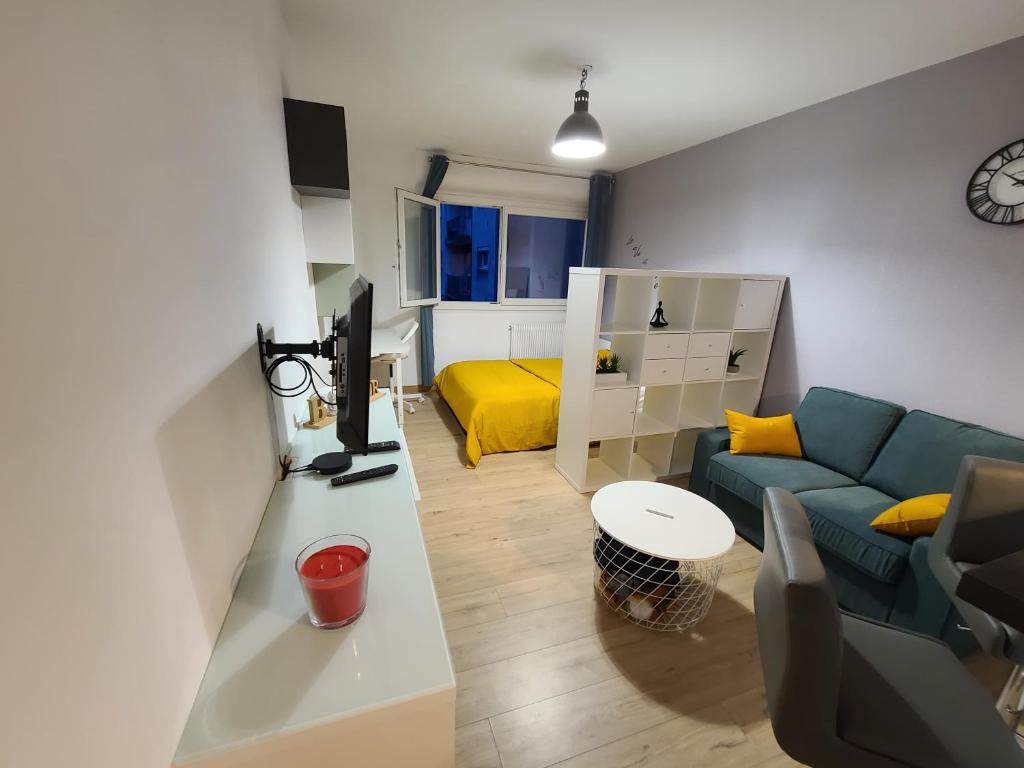 sala de estar con sofá azul y cama amarilla en Magnifique Studio 26m2, en Belfort