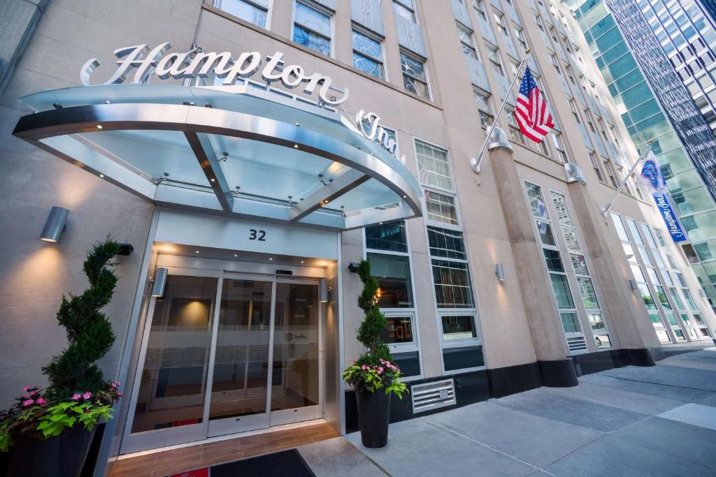 una entrada a un hotel Hampton con una bandera americana en Hampton Inn Manhattan/Downtown- Financial District, en Nueva York