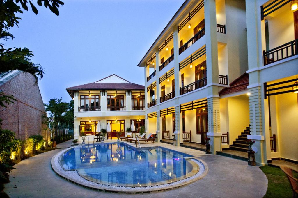 a house with a swimming pool in front of it at Hoi An TNT Villa in Hoi An