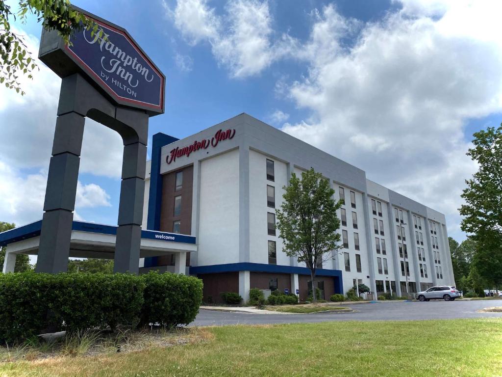 un gran edificio blanco con un cartel delante en Hampton Inn Lexington Park, en Lexington Park