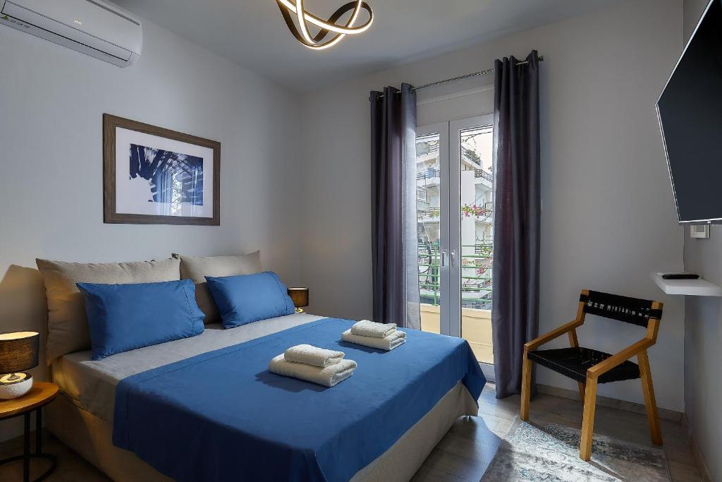 a bedroom with a blue bed and a chair at Domenico Homes - City Center in Heraklio