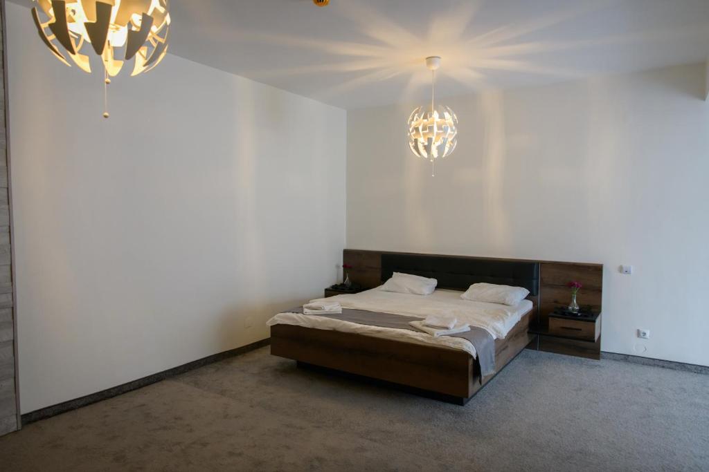 a bedroom with a bed and two chandeliers at Hotel Vegas Negreni in Negreni