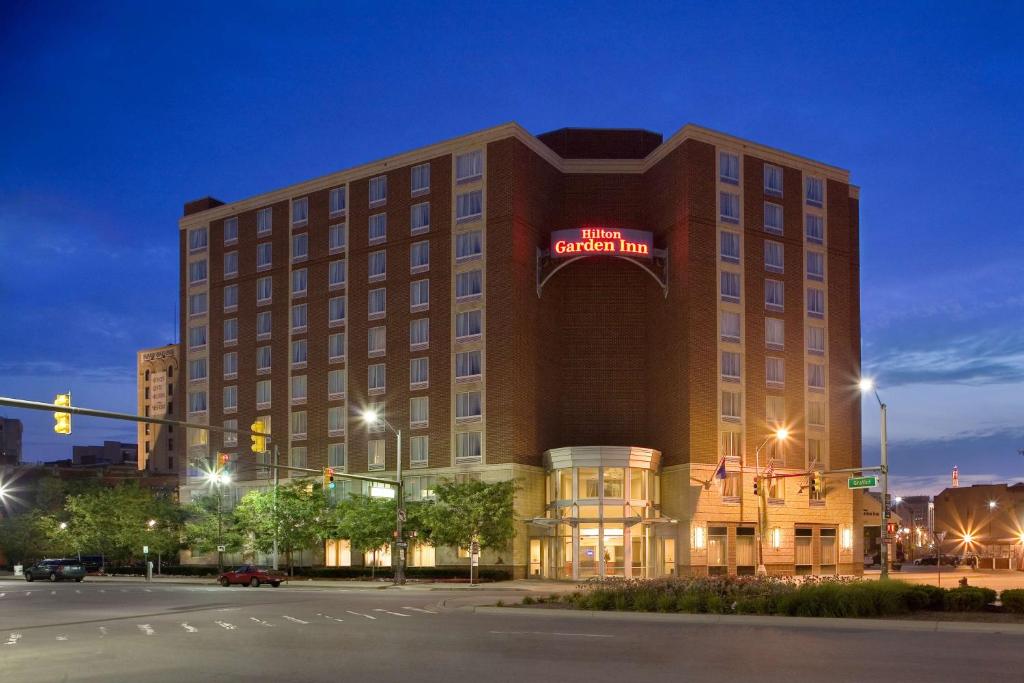 a hotel building with a sign on it at night at Hilton Garden Inn Detroit Downtown in Detroit