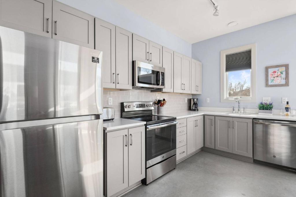 a kitchen with stainless steel appliances and white cabinets at Alloy 374-7 in Nashville