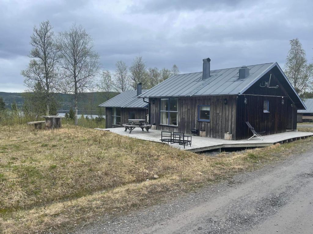 a large wooden house with a picnic table on a field at Fjällstuga Huså in Åre