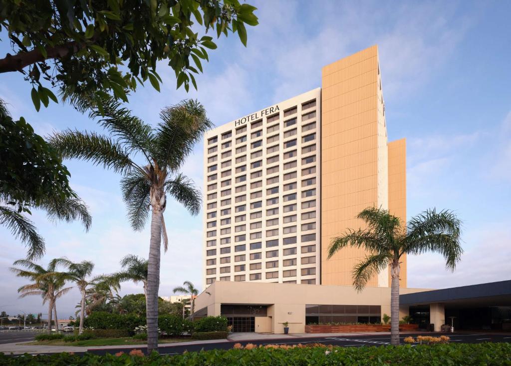 a hotel building with palm trees in front of it at Hotel Fera Anaheim, a DoubleTree by Hilton Hotel in Anaheim