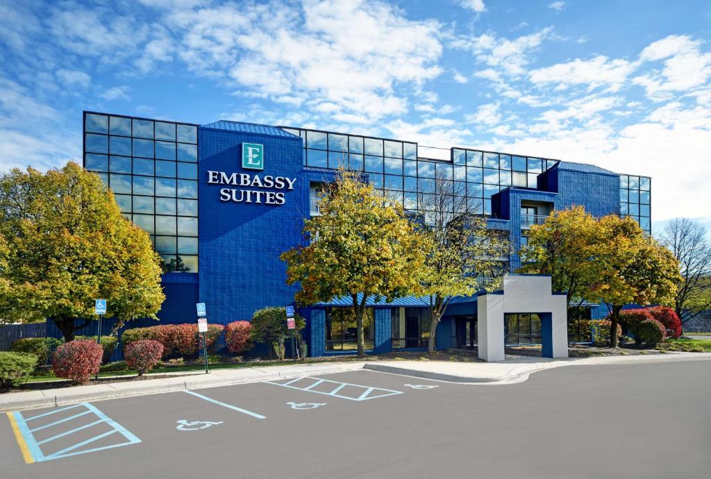 un edificio azul con un cartel en el costado en Embassy Suites by Hilton Detroit - Livonia/Novi, en Livonia