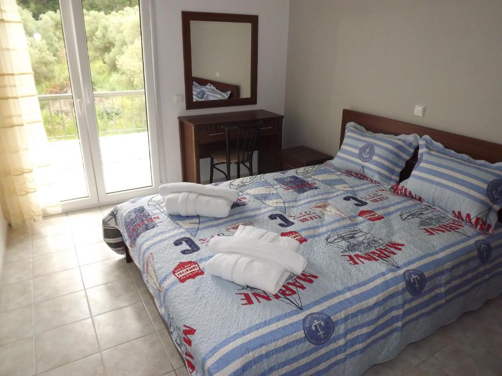 a bedroom with a bed with two baseball pillows on it at Istira in Possidi