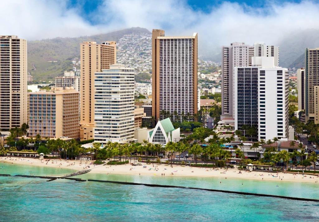 une ligne d'horizon d'une ville avec une plage et des bâtiments dans l'établissement Hilton Waikiki Beach, à Honolulu